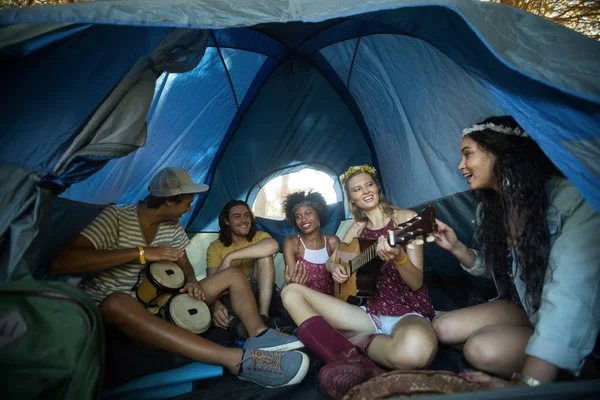 Young friends enjoying in tent — Stock Photo, Image