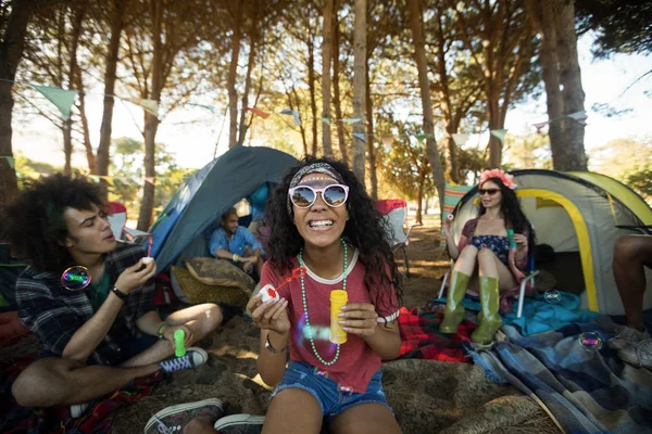 Kvinna som håller bubblan trollspö på campingplats — Stockfoto