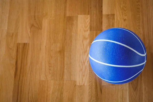 Синий баскетбол на паркете — стоковое фото