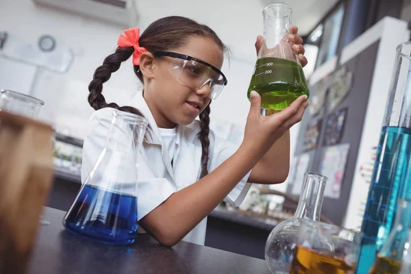 Student, zkoumání chemické látky v baňce při teplotě laboratoře — Stock fotografie