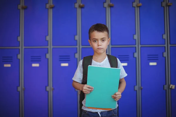 Niño sosteniendo libros contra casilleros —  Fotos de Stock