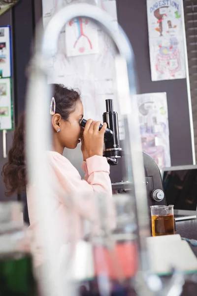 Ученик-первокурсник смотрит в микроскоп — стоковое фото