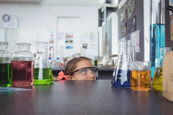 Elementární student schovává za stolem — Stock fotografie