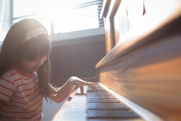 Ragazza elementare che pratica il pianoforte in classe — Foto Stock