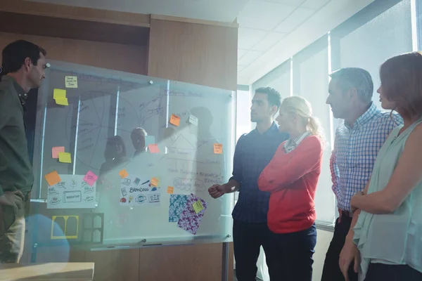 Mensen uit het bedrijfsleven bespreken door whiteboard — Stockfoto