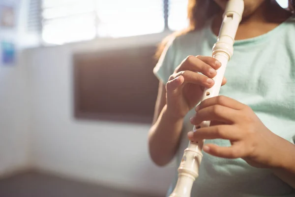 Flicka spela flöjt i klassrummet — Stockfoto