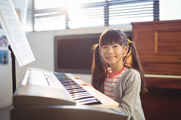 Leende flicka öva piano — Stockfoto