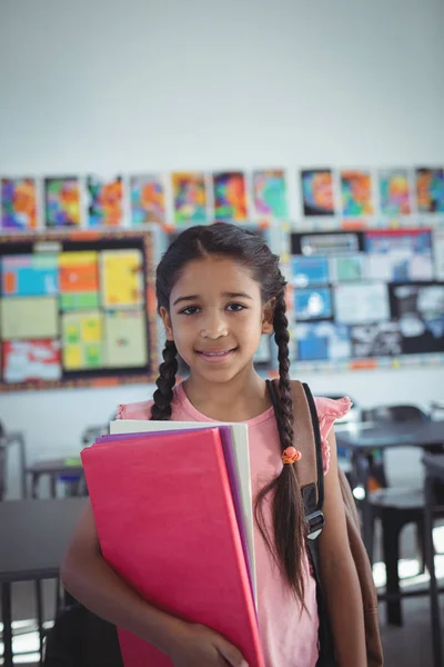 Menina com livros em sala de aula — Fotografia de Stock