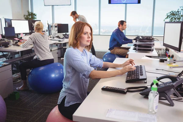 Empresária atenciosa sentada na bola de exercício — Fotografia de Stock