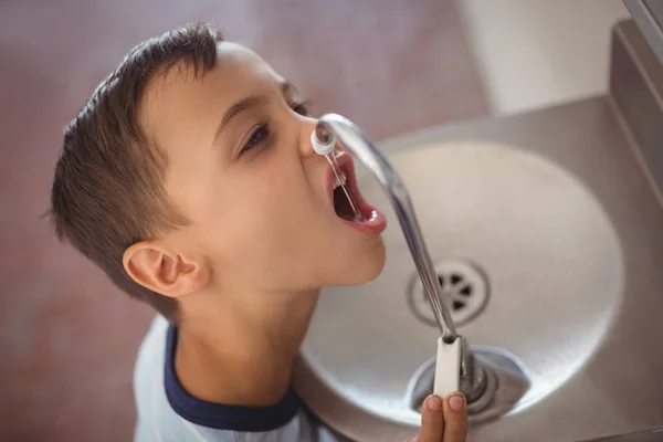 Jongen drinkwater uit de kraan — Stockfoto