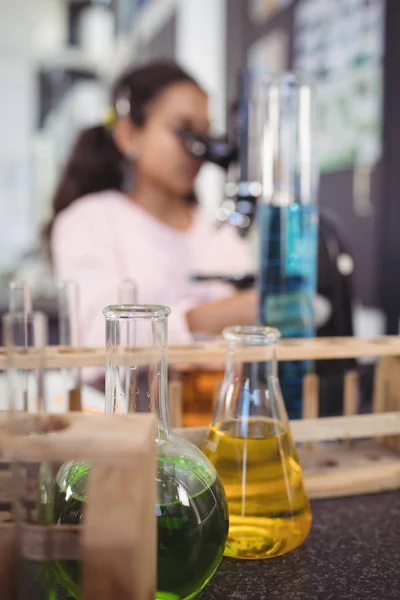 Kemikalier på skrivbord med elementära student — Stockfoto