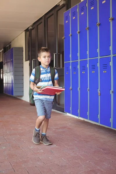 Garçon portant des livres dans le couloir — Photo