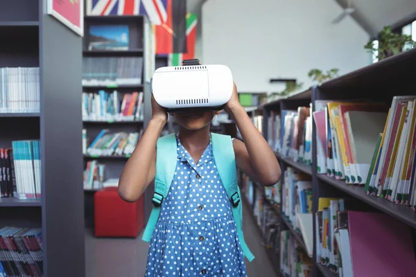 Menina vestindo simulador de realidade virtual na biblioteca — Fotografia de Stock