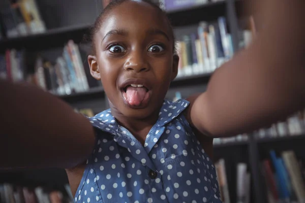 Mädchen macht Gesicht in Bibliothek — Stockfoto