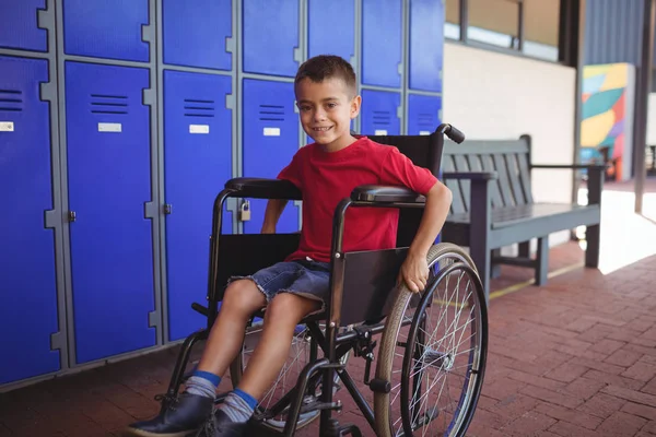 Мальчик сидит на инвалидной коляске в коридоре — стоковое фото