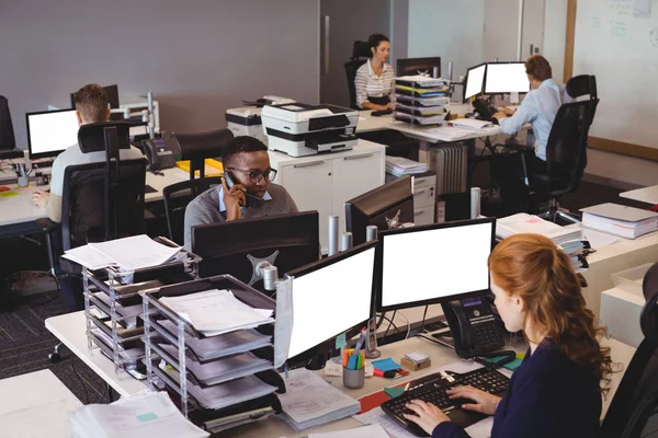 Mensen uit het bedrijfsleven werken bij balie in kantoor — Stockfoto