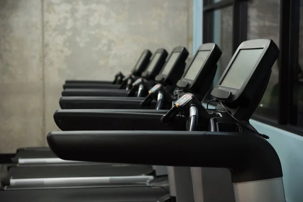 Tapis roulants en rangée à la salle de gym vide — Photo