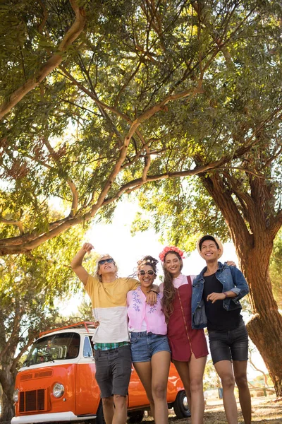 Smiling friends walking on field — Stock Photo, Image