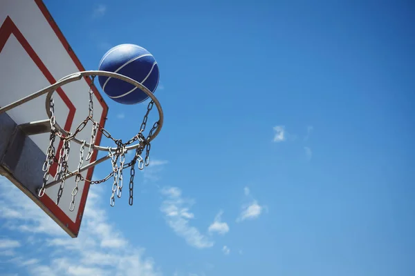 Синий баскетбол в обруче — стоковое фото
