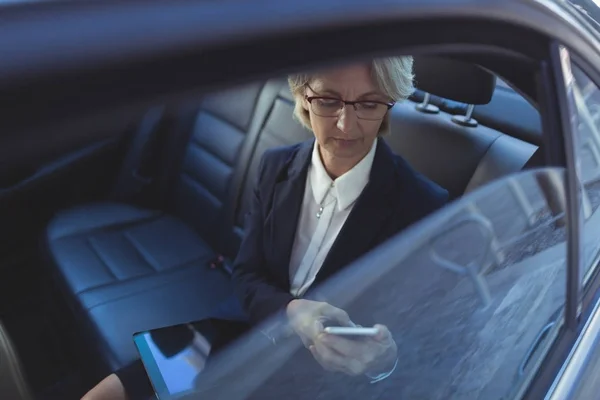 Donna d'affari che utilizza il telefono in auto — Foto Stock