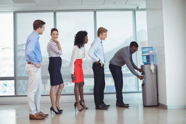 Business people standing by water cooler — Stock Photo, Image