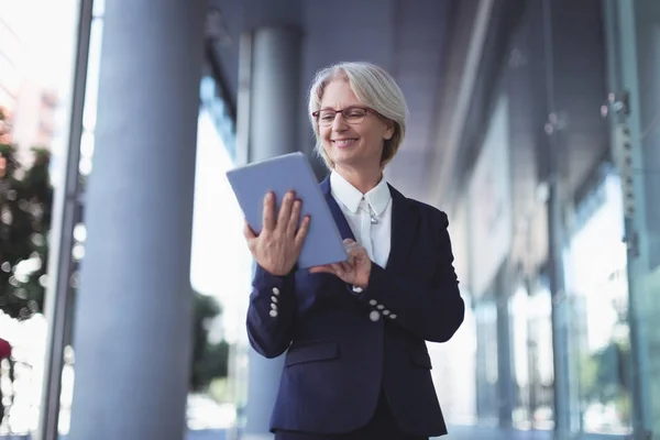 Mujer de negocios sonriente usando tableta digital — Foto de Stock