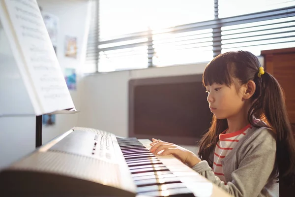 Koncentrerad flicka öva piano i klass — Stockfoto