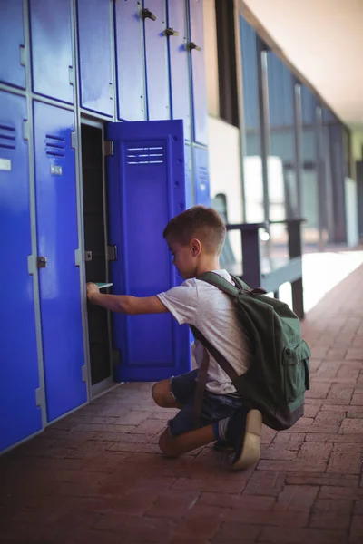 Jongen nemen boeken uit locker — Stockfoto