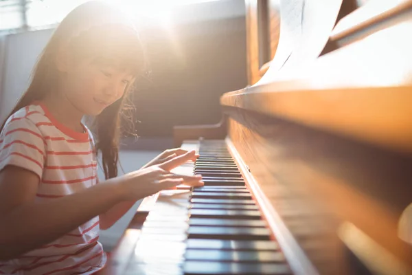 Flicka öva piano i klassrummet — Stockfoto