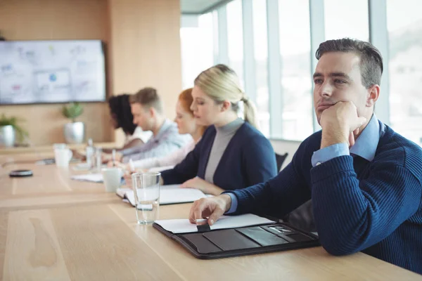 Tankeväckande affärsman sitter med kollegor som arbetar — Stockfoto