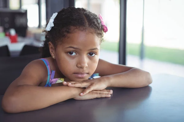 Menina inclinada na mesa na escola — Fotografia de Stock