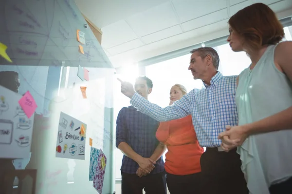 Mensen uit het bedrijfsleven bespreken over whiteboard — Stockfoto