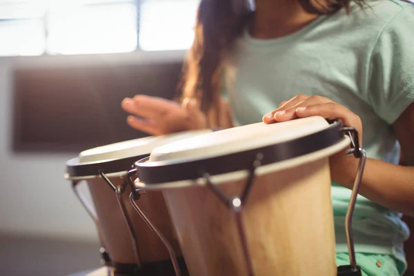 教室でボンゴドラムを弾いている女の子 — ストック写真