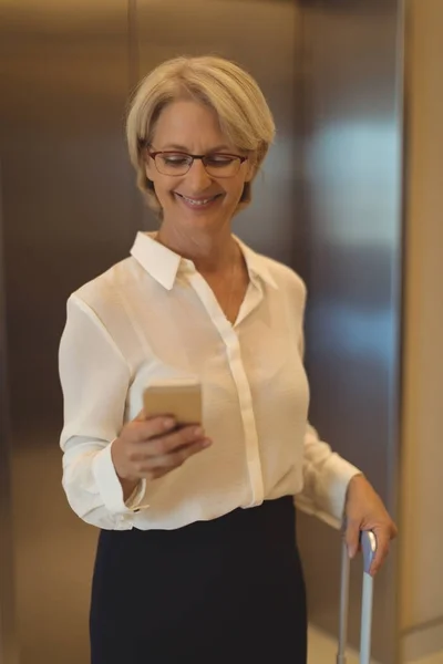 Glimlachende zakenvrouw met behulp slimme telefoon — Stockfoto