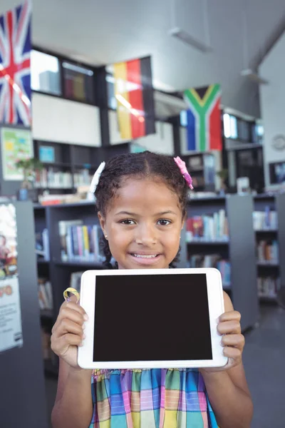 Menina mostrando tablet computador na biblioteca — Fotografia de Stock
