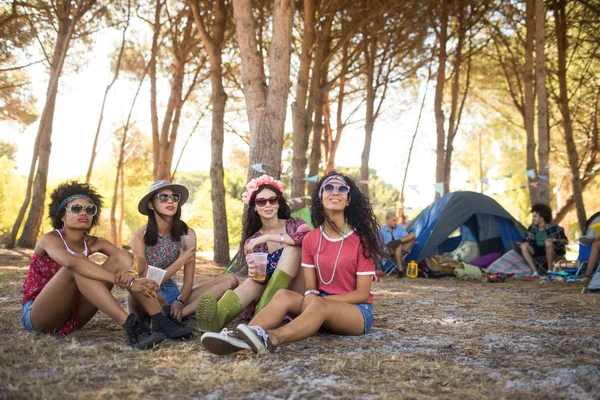 Amigos do sexo feminino sentados no acampamento — Fotografia de Stock