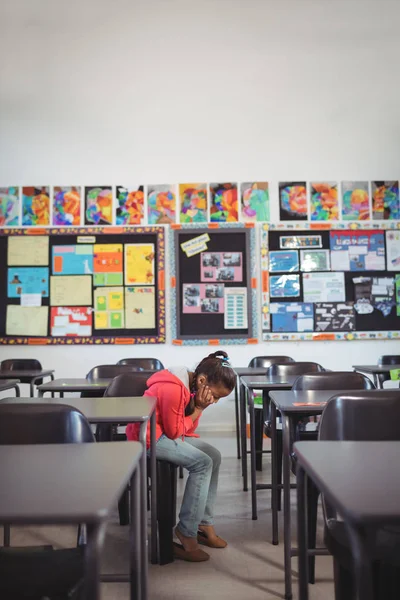 Mädchen sitzt auf Stuhl im Klassenzimmer — Stockfoto