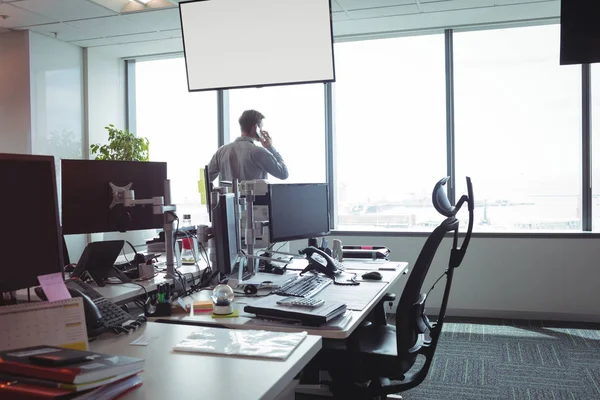 Geschäftsmann greift am Fenster zum Telefon — Stockfoto