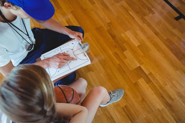 Coach explaining diagram to basketball player — Stock Photo, Image