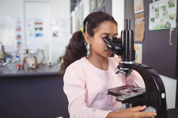 Grundschülerin mit Mikroskop im Labor — Stockfoto