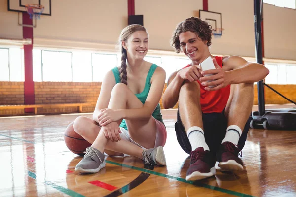 Amigos sonrientes usando un teléfono inteligente — Foto de Stock