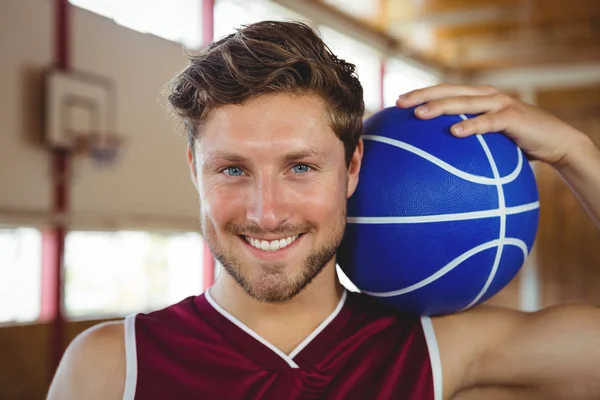 Smiling basketball player holding ball — Stock Photo, Image