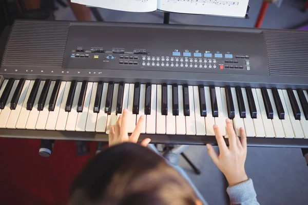 Menina tocando piano na sala de aula na escola — Fotografia de Stock