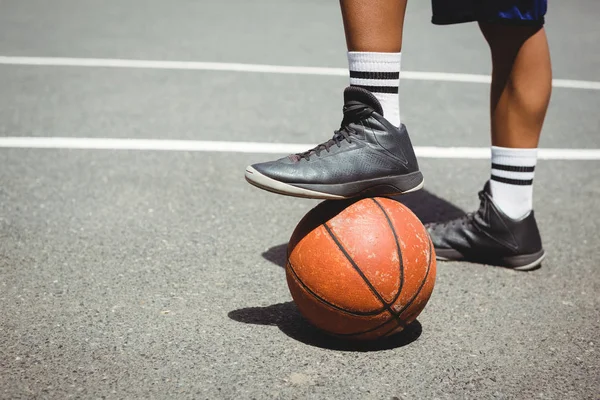 Mężczyzna stojący z jedną nogą na koszykówkę — Zdjęcie stockowe