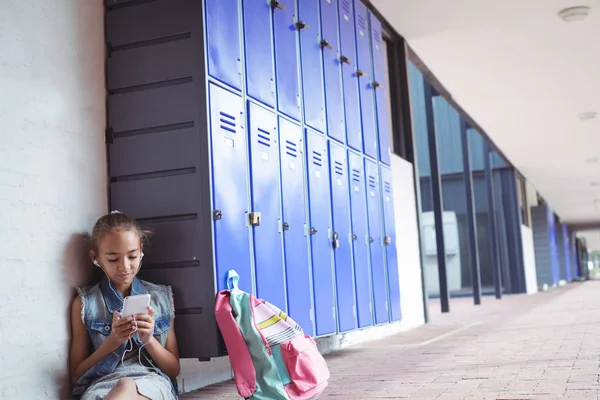 Colegiala elemental escuchando música a través de auriculares — Foto de Stock