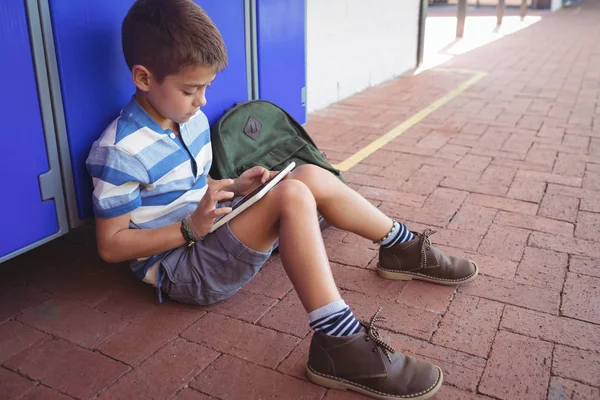 Jongen met behulp van Tablet PC zittend door locker — Stockfoto