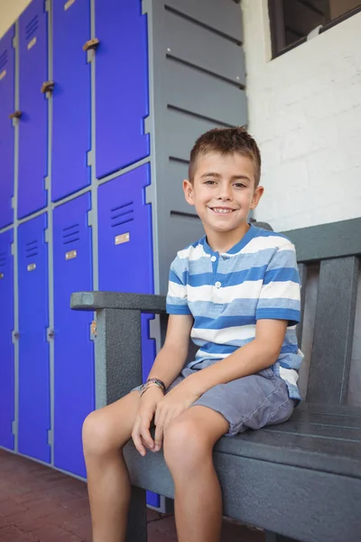 男孩坐在长椅上的储物柜 — 图库照片