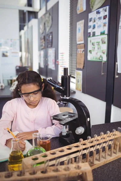 Studente elementare concentrato che scrive nel libro — Foto Stock