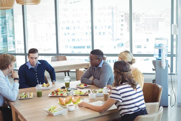 Empresários almoçando no refeitório do escritório — Fotografia de Stock
