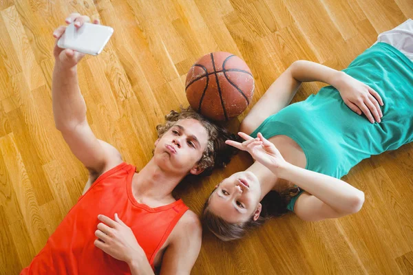 Amici prendendo selfie mentre sdraiato sul pavimento — Foto Stock